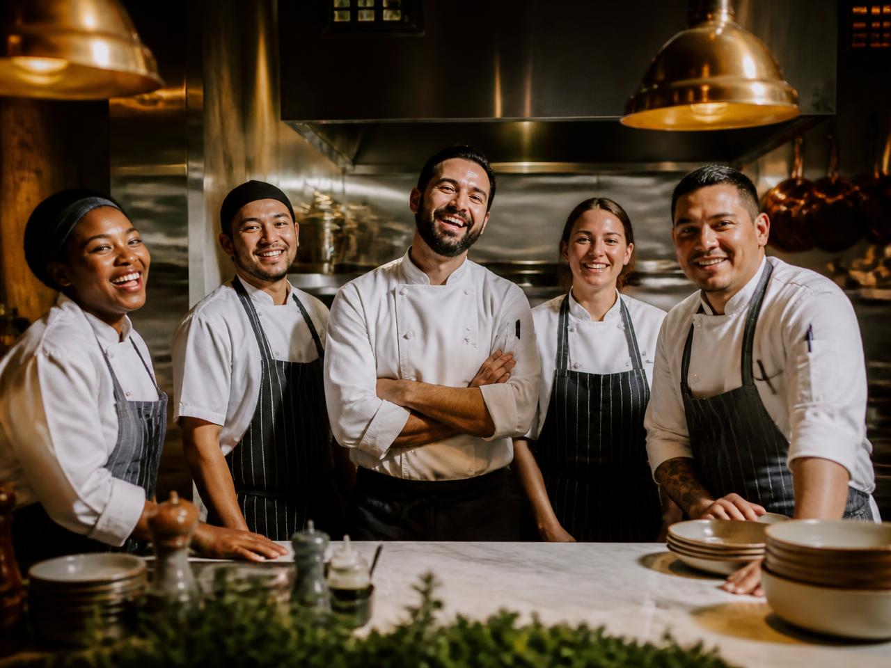 Smiling chefs and line cooks in the Driftwood kitchen